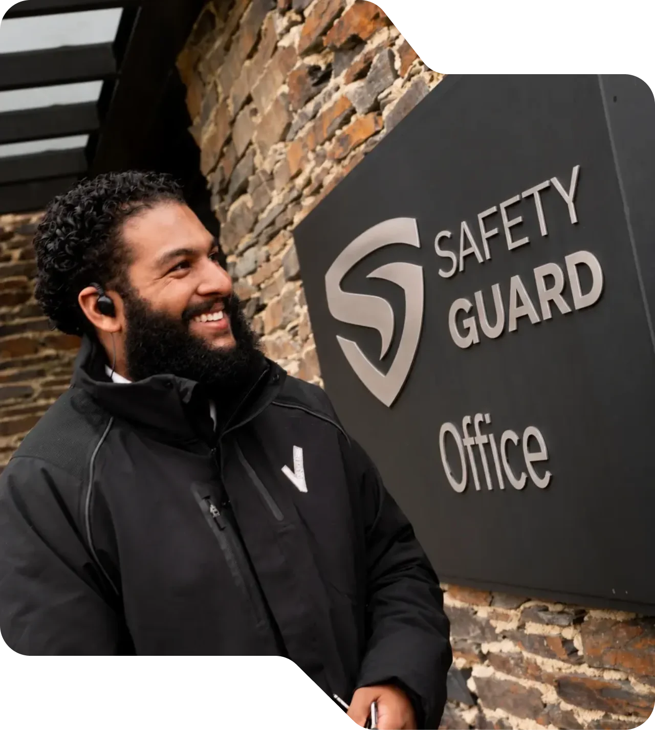 Lachende beveiliger van Safety Guard bij het bord van het kantoor